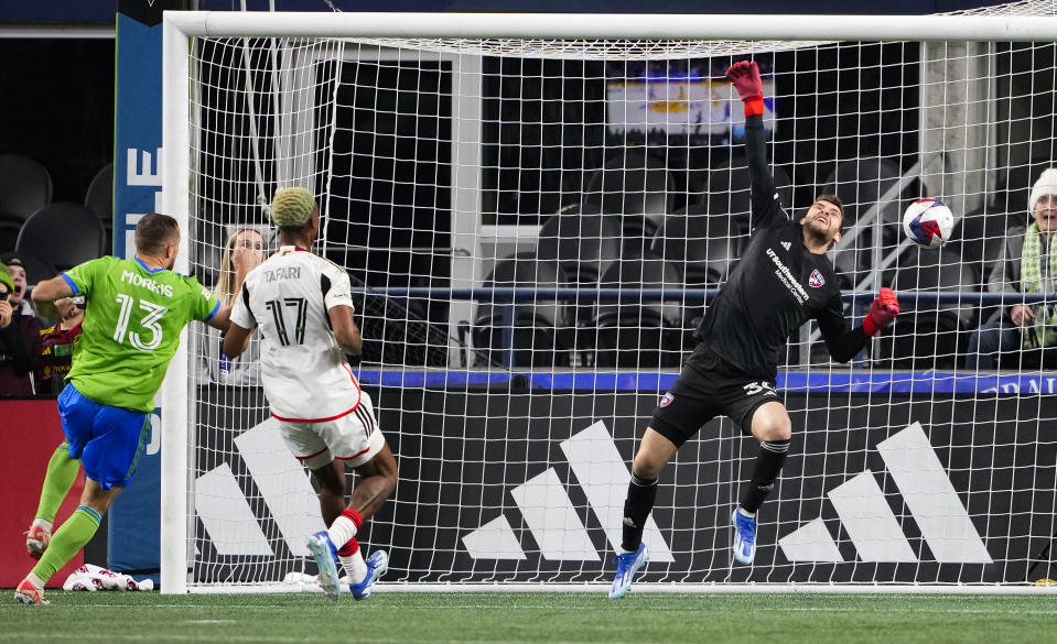 FC Dallas goalkeeper Maarten Paes, right, cannot get a hand on a goal by Seattle Sounders forward Jordan Morris (13) as Dallas defender Nkosi Tafari (17) looks on during the second half of an MLS playoff soccer match Monday, Oct. 30, 2023, in Seattle. (AP Photo/Lindsey Wasson)