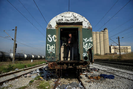 An Algerian migrant smokes inside an abandoned railway wagon used as a shelter by stranded migrants, in the northern city of Thessaloniki, Greece, April 5, 2017. REUTERS/Alexandros Avramidis