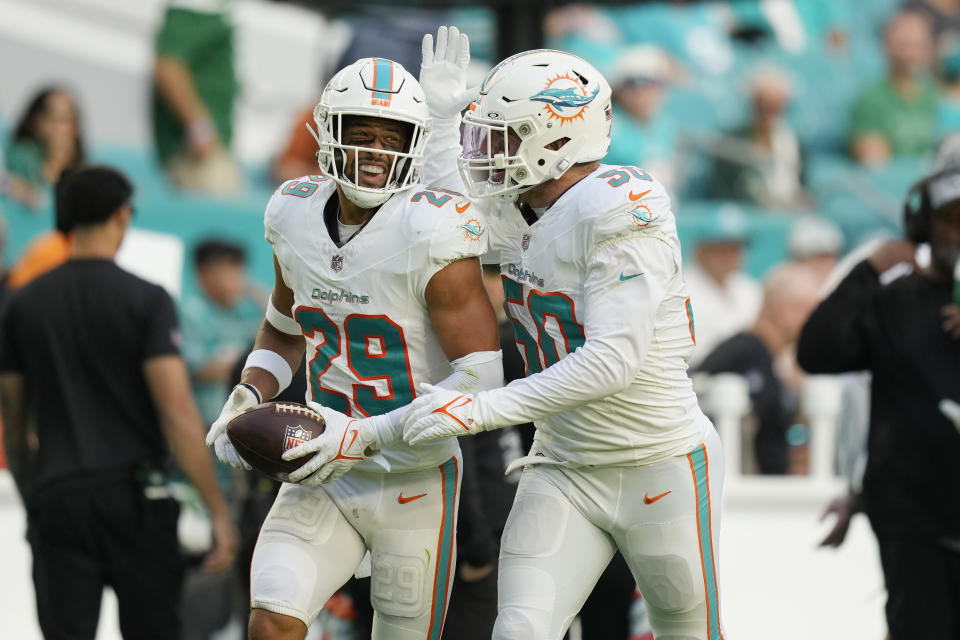 Miami Dolphins safety Brandon Jones (29) is congratulated by linebacker Calvin Munson (50) after intercepting a pass during the second half of an NFL football game against the New York Jets, Sunday, Dec. 17, 2023, in Miami Gardens, Fla. The Dolphins defeated the Jets 30-0. (AP Photo/Rebecca Blackwell)
