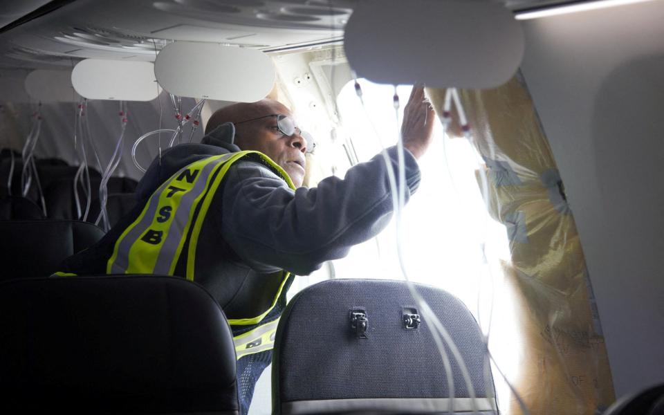 National Transportation Safety Board investigator-in-charge John Lovell examines the fuselage plug area of the Alaska Airlines Boeing plane