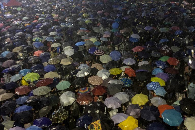 Unos manifestantes prodemocráticos usan sus paraguas para protegerse de las fuertes lluvias caídas durante las protestas en Hong Kong, el 30 de septiembre de 2014