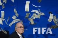 FIFA president Sepp Blatter looks on with fake dollars note flying around him thrown by a protester during a press conference at the football's world body headquarter's on July 20, 2015 in Zurich. FIFA said Monday that a special election will be held on February 26 to replace president Sepp Blatter. AFP PHOTO / FABRICE COFFRINI (Photo credit should read FABRICE COFFRINI/AFP via Getty Images)