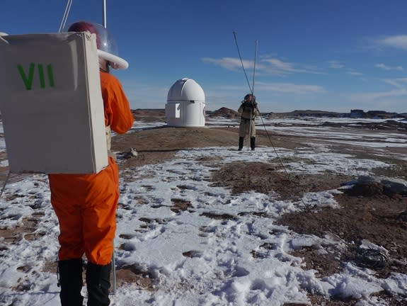 Crew 133 members Matthieu Komorowski (left) and Joseph Jessup setting up a radio telescope just outside Utah's Mars Desert Research Station. In the background is the facility's astronomy observatory.