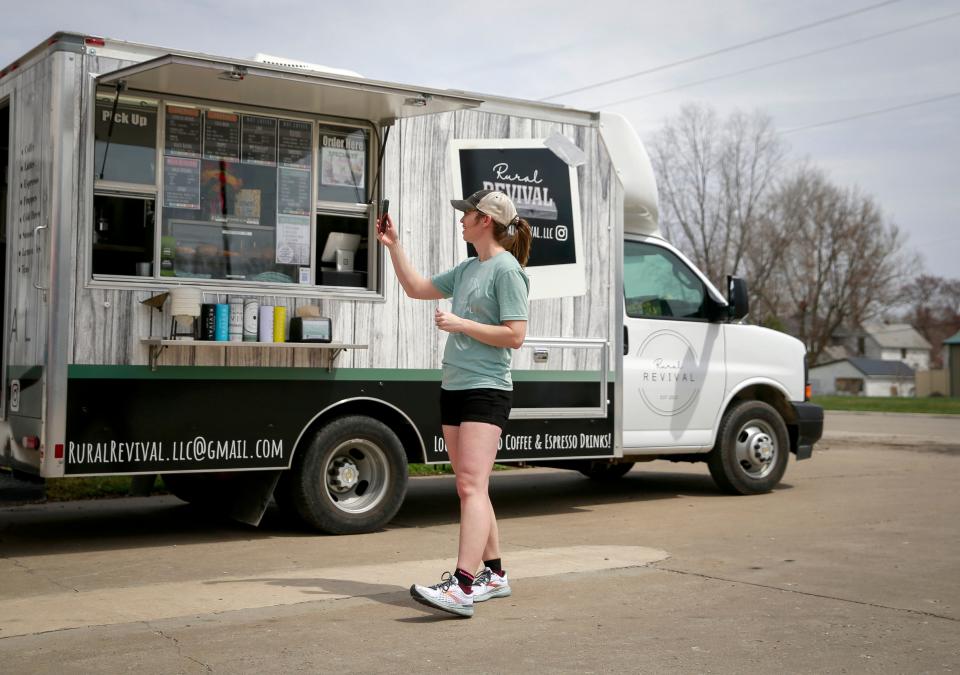 Sky Hahn records a reel for Instagram during a moment of downtime between waves of customers at the Rural Revival mobile coffee truck spot in Keota, Iowa, on Saturday, April 23, 2022.