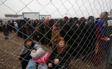 Displaced Iraqi people stand in line to receive aid as Iraqi forces battle with Islamic State militants in Mosul, at Hammam al-Alil camp, Iraq March 23, 2017. REUTERS/Khalid al Mousily