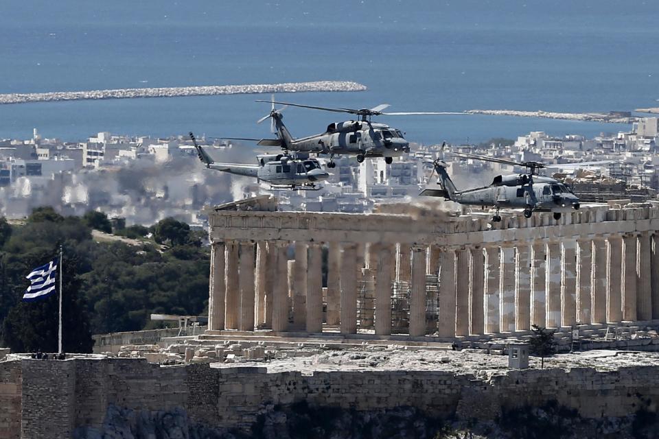 Military helicopters fly over the Parthenon, on the ancient Acropolis hill during a parade in Athens, Tuesday, March 25, 2014, to commemorate Greek Independence Day. The national holiday on March 25 marks the start of Greece's 1821 war of independence against the 400-year Ottoman rule. (AP Photo/ Petros Giannakouris)