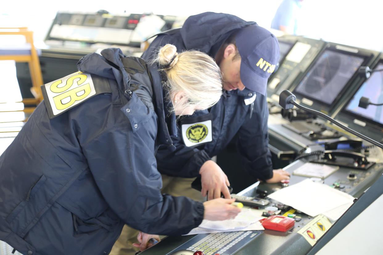 NTSB investigators are seen March 27, 2024, on the cargo vessel Dali, which struck and collapsed the Francis Scott Key Bridge on March 26, 2024.