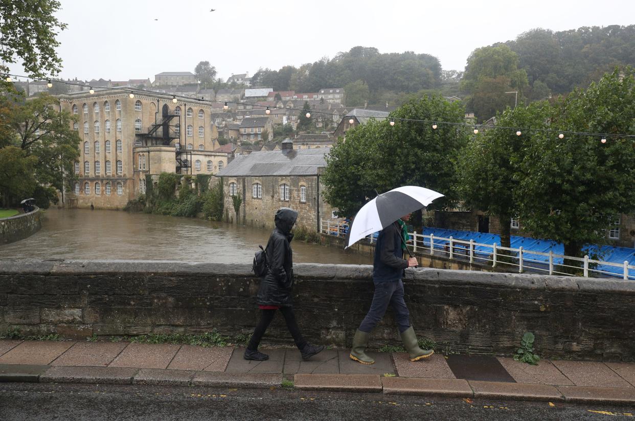 People walk in the rain in Bradford-on-Avon in Wiltshire on 4 October, 2020.  (PA)