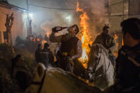 <p>A rider drinks wine next to a bonfire during a ritual in honor of St. Anthony the Abbot, the patron saint of domestic animals, in San Bartolomé de Pinares, about 62 miles west of Madrid, Jan. 16, 2015. (AP Photo/Andres Kudacki) </p>