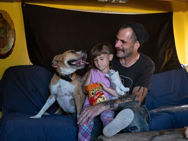 Chris Geddis sits in his RV with his daughter, Lilith, and their dog, Bourbon. (Photo: Molly Peters for HuffPost)