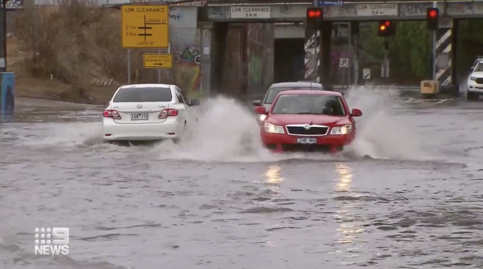 Cars in West Melbourne drive through wet streets.