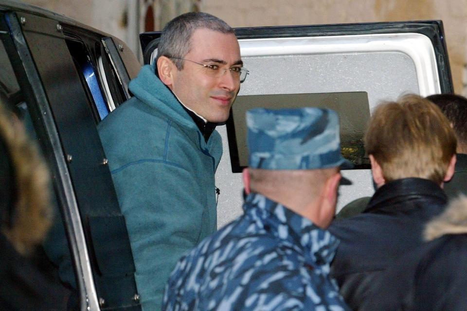 FILE - Mikhail Khodorkovsky, the former chief of Russia's largest oil company, Yukos, gets out of an armored police car on his way to court in Moscow, Dec. 22, 2003. (AP Photo/Alexander Zemlianichenko, File)
