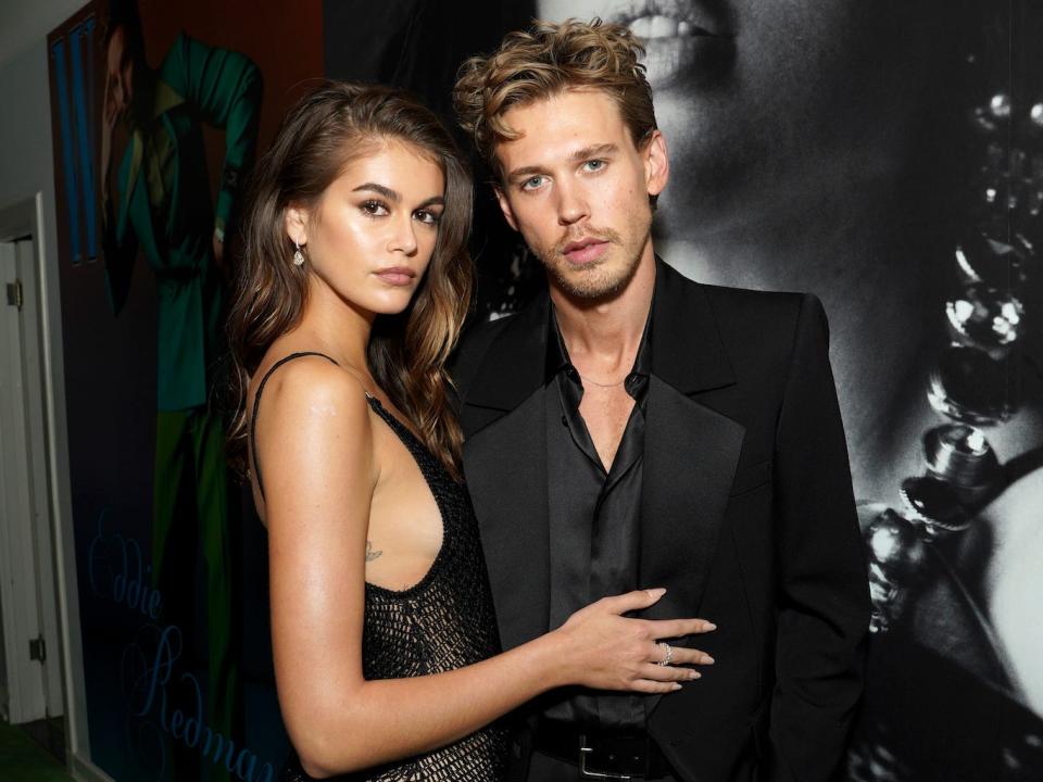 Kaia Gerber in a black dress and Austin Butler in a black suit posing