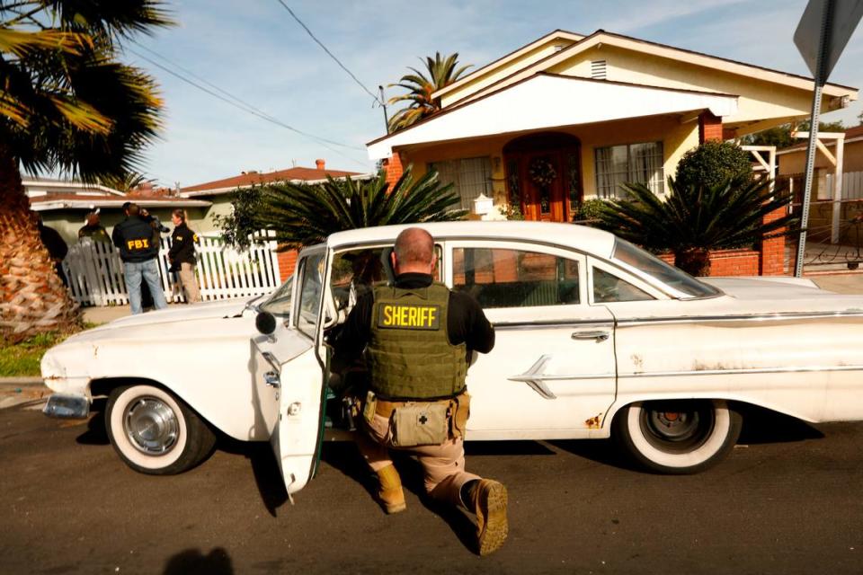 Sheriff’s deputies search the car of suspect Paul Flores on Feb. 5, 2020, in the case of missing student Kristin Smart, who vanished from Cal Poly San Luis Obispo in 1996. Flores was released after a thorough check of his home and vehicles in San Pedro, California. He has since been arrested and charged with her murder.