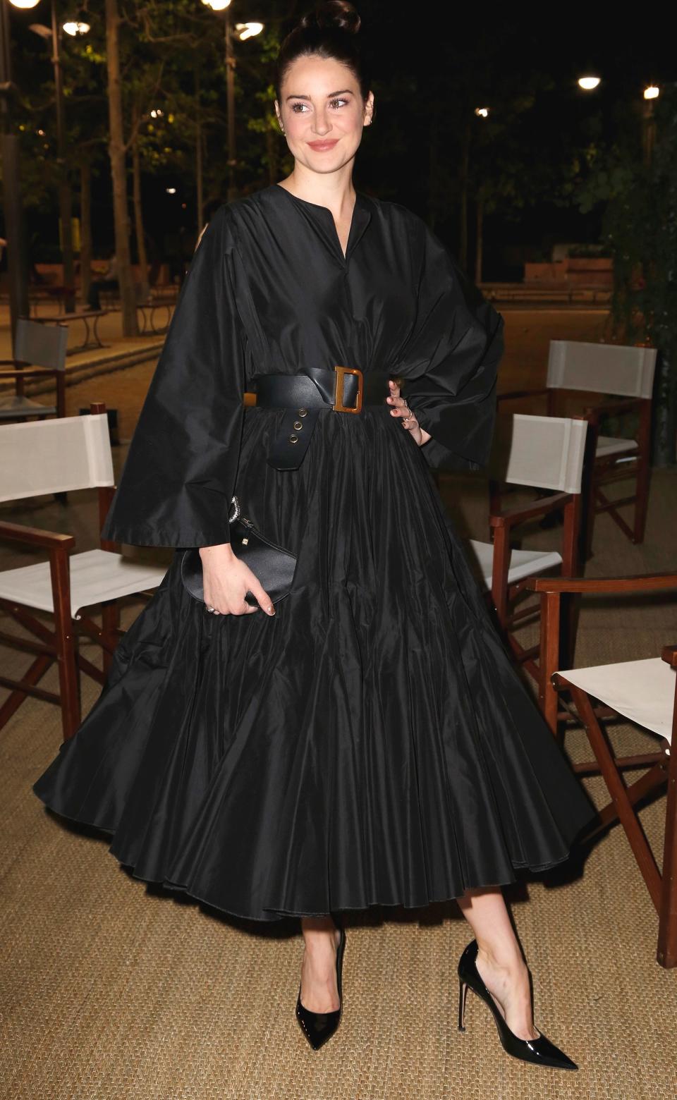 The actress arrives at the Dior x <em>Vogue Paris</em> dinner wearing a black Dior shirtdress with pleated skirt, with a belt, bag and shoes by the brand.