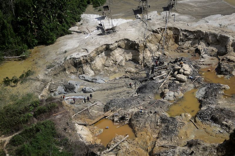 Mineros ilegales son sorprendidos utilizando chorros de agua para excavar en busca de oro, dañando el suelo junto a la orilla del río Couto de Magalhaes, durante una operación llevada a cabo por miembros del Grupo Especial de Inspección del Instituto Brasileño de Medio Ambiente y Recursos Naturales Renovables (IBAMA) contra la minería ilegal en tierra indígena yanomami, estado de Roraima