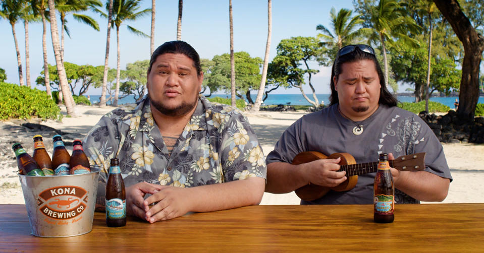 Two men, one with a ukulele, and Kona beer