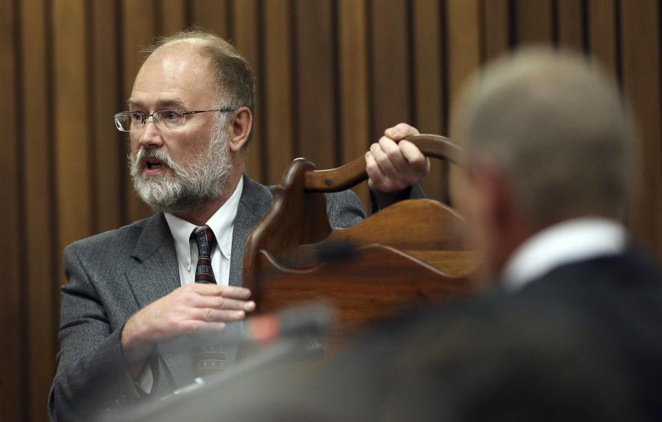 Defense expert witness Roger Dixon (L) holds a magazine rack as Prosecutor Gerrie Nel (R) looks on during the murder trial of South African Olympic and Paralympic athlete Oscar Pistorius in the North Gauteng High Court in Pretoria April 17, 2014. Pistorius is on trial for murdering his girlfriend Reeva Steenkamp at his suburban Pretoria home on Valentine's Day last year. REUTERS/Themba Hadebe/Pool (SOUTH AFRICA - Tags: SPORT CRIME LAW ATHLETICS)