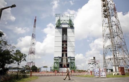 A security personnel officer walks in front of the Polar Satellite Launch Vehicle (PSLV-C25), carrying the Mars orbiter, before its launch at Satish Dhawan Space Centre in Sriharikota, about 100 km (62 miles) north of the southern Indian city of Chennai, October 30, 2013. REUTERS/Stringer/Files