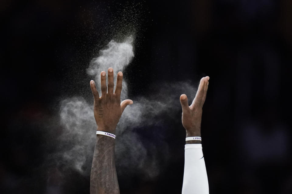 Los Angeles Lakers' LeBron James tosses powder before the team's NBA preseason basketball game against the Minnesota Timberwolves on Wednesday, Oct. 12, 2022, in Los Angeles. (AP Photo/Jae C. Hong)