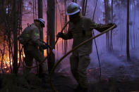<p>Portuguese National Republican Guard firefighters work to stop a forest fire from reaching the village of Avelar, central Portugal, at sunrise Sunday, June 18 2017. (Armando Franca/AP), </p>