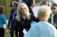 Actress Loni Anderson, the former wife of the late actor Burt Reynolds, greets actress Ruta Lee, foreground, at the unveiling of a memorial sculpture of Reynolds at Hollywood Forever Cemetery, Monday, Sept. 20, 2021, in Los Angeles. Reynolds died in 2018 at the age of 82. (AP Photo/Chris Pizzello)