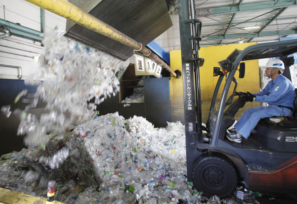 In this June 18, 2019, photo, a plastic recycling company worker adds used plastic bottles into bale breaker for processing, at Tokyo Petbottle Recycle Co., Ltd, in Tokyo. Japan has a plastic problem. Single bananas here are sometimes wrapped in plastic. So are individual pieces of vegetables, fruit, pastries, pens and cosmetics. Plastic-wrapped plastic spoons come with every ice cream cup. But as world leaders descend on Osaka for the two-day G20 Summit that starts Friday, June 28, Japan has ambitions to become a world leader in reducing plastic waste. (AP Photo/Koji Sasahara)