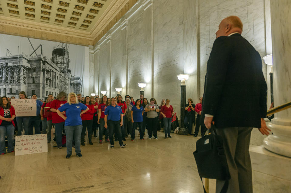 CORRECTS DAY OF WEEK TO WEDNESDAY - Teachers and school personnel, on the second day of a statewide strike, listen as West Virginia Education Association President Dale Lee speaks outside the House of Delegates chamber, Wednesday, Feb. 20, 2019, at the West Virginia State Capitol in Charleston, W.Va. West Virginia public school teachers are striking for a second day even though legislation they loathed was tabled in the House of Delegates. Schools in 54 of the state's 55 counties were closed Wednesday. The lone holdout again was Putnam County. (Craig Hudson/Charleston Gazette-Mail via AP)