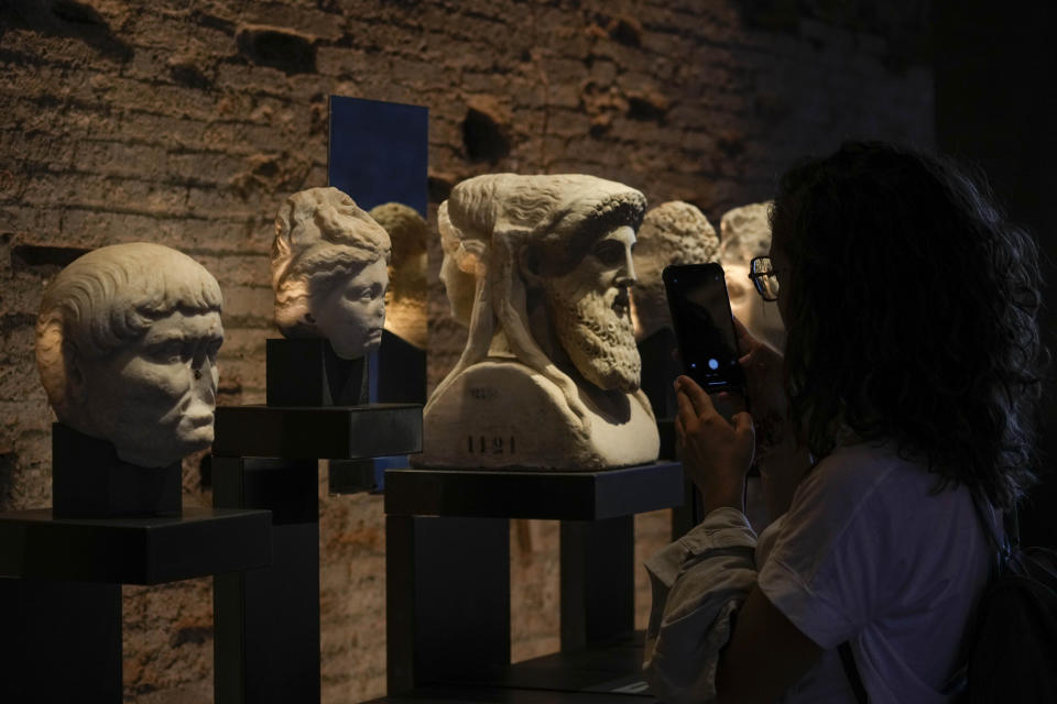 A visitor admires archeological finds inside the newly restored domus Tiberiana, one of the main imperial palaces, during the press preview on Rome's Palatine Hill, in Rome, Italy, Wednesday, Sept. 20, 2023. The Domus Tiberiana will reopen to the public on Sept. 21. (AP Photo/Gregorio Borgia)