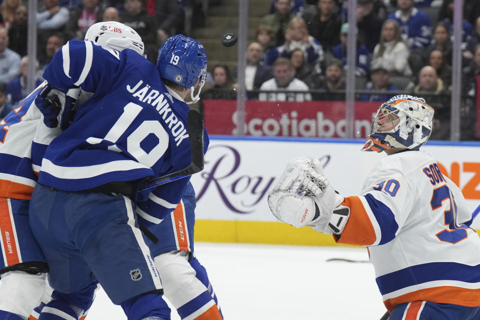 New York Islanders goaltender Ilya Sorokin (30) watches the puck as Toronto Maple Leafs center Calle Jarnkrok (19) battles in front of the net during second-period NHL hockey game action in Toronto, Ontario, Monday, Jan. 23, 2023. (Nathan Denette/The Canadian Press via AP)