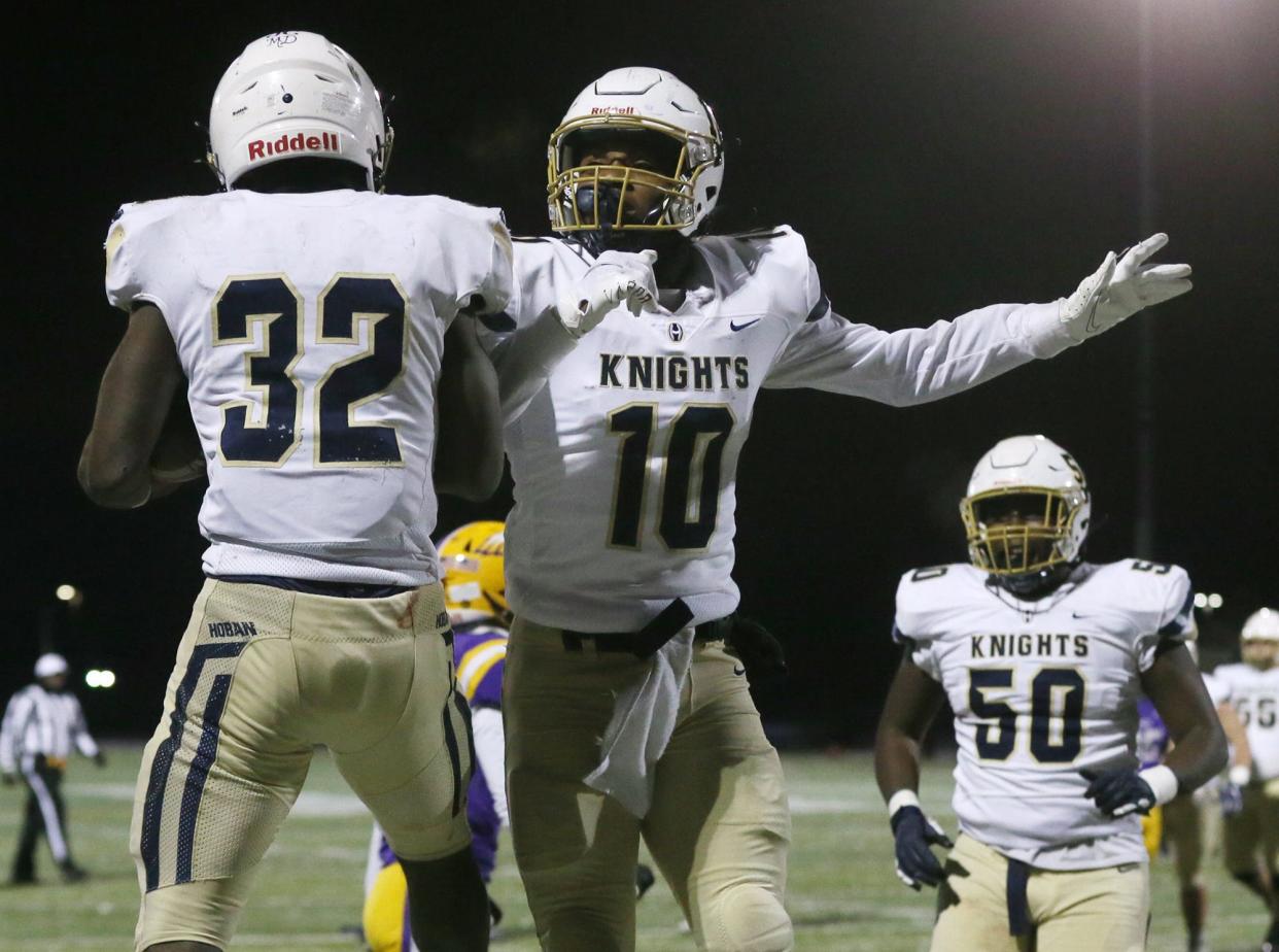 Hoban's Lamar Sperling (32) celebrates scoring a touchdown against Avon with Rickey Williams as Will Satterwhite (50) looks on during a Division II state semifinal at Byers Field in Parma.