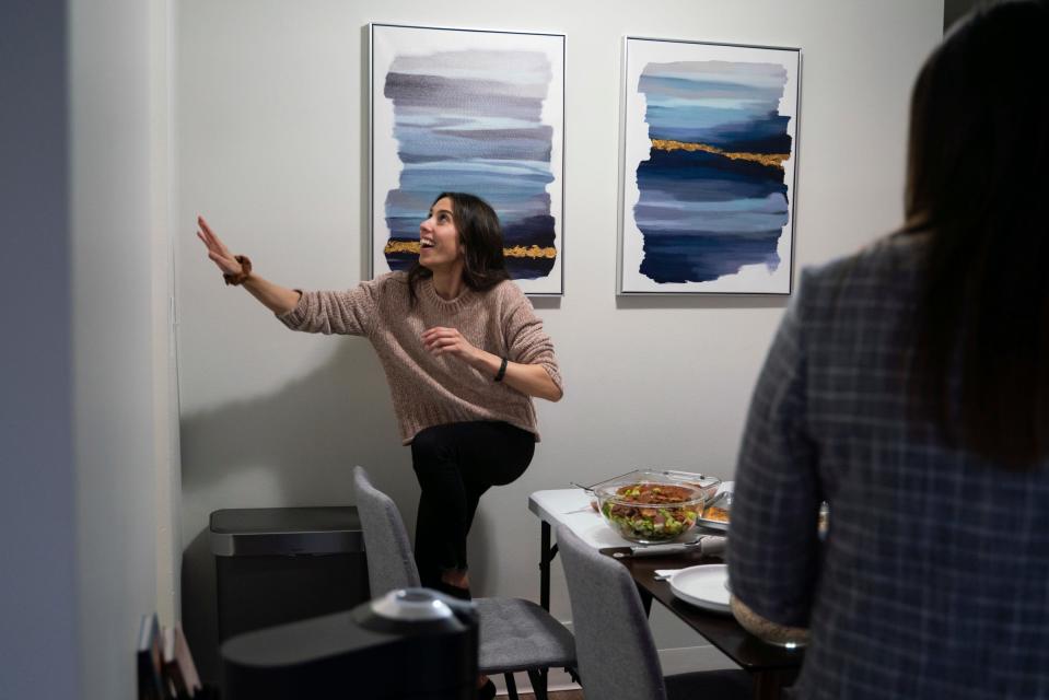 Detroit Free Press reporter Dana Afana, 31, reaches for the smoke detector while cooking dinner with friends for Iftar, a fast-breaking meal eaten after sunset during Ramadan on Tuesday, March 28, 2023.