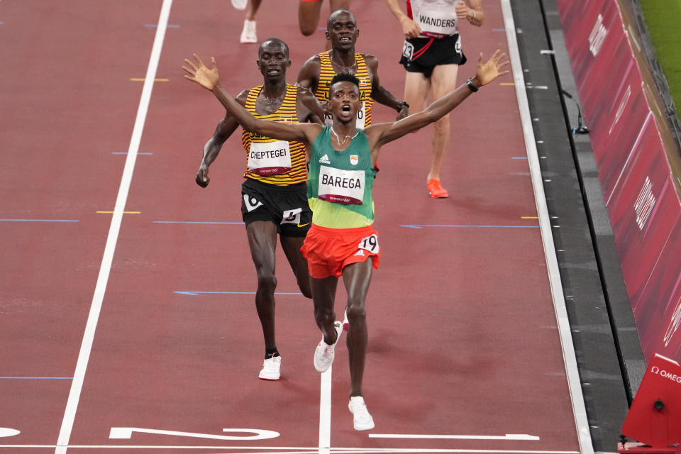 Selemon Barega, of Ethiopia, celebrates after winning the men's 10,000-meter run at the 2020 Summer Olympics, Friday, July 30, 2021, in Tokyo. (AP Photo/Charlie Riedel)