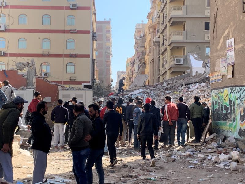 People inspect the area where a building was collapsed in Gesr al-Suez, Cairo