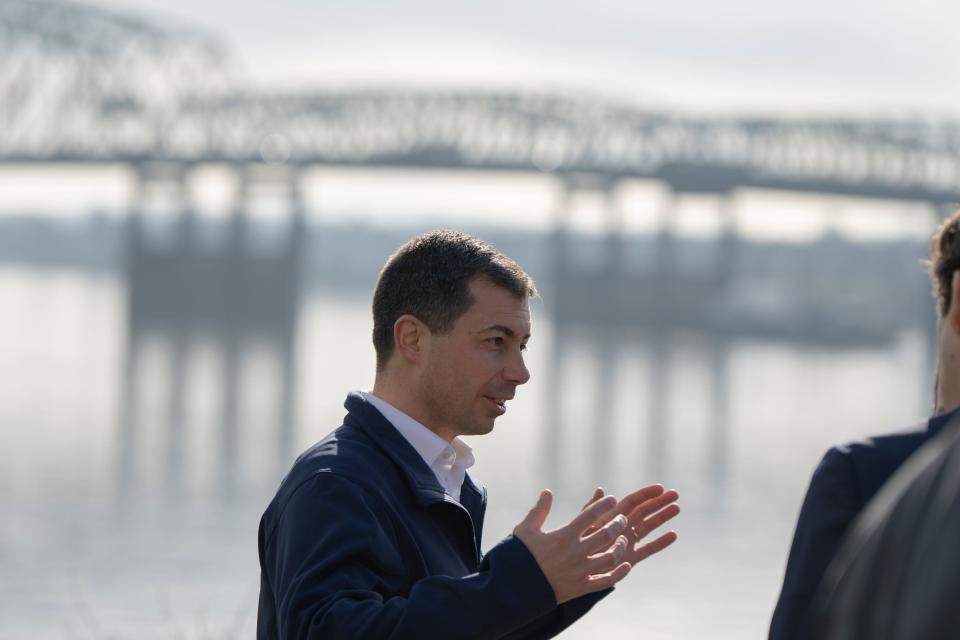 U.S. Transportation Secretary Pete Buttigieg speaks with members of the media during a February visit to Vancouver, Wash., with the century-old Interstate 5 bridge behind him.