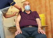 82-year-old Brian Pinker receives the Oxford University/AstraZeneca COVID-19 vaccine from nurse Sam Foster at the Churchill Hospital in Oxford, England, Monday, Jan. 4, 2021. Pinker, a retired maintenance manager received the first injection of the new vaccine developed by between Oxford University and drug giant AstraZeneca. (Steve Parsons/Pool Photo via AP)