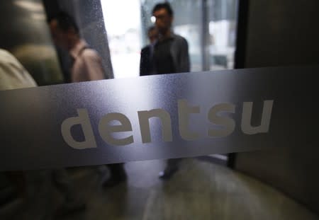 FILE PHOTO: The logo of Dentsu Co. is seen at the entrance of the company headquarters in Tokyo