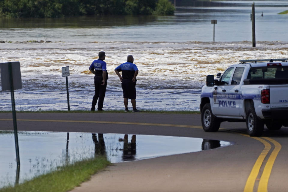 Police officers observe the water release from the Ross Barnett Reservoir Spillway onto the Pearl River in Rankin County, Miss., on Sunday.  (Rogelio V. Solis / AP)