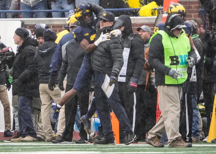 Michigan Wolverines wide receiver A.J. Henning (3) celebrates scoring a touchdown with head coach Jim Harbaugh during the first quarter of the NCAA football game at Michigan Stadium in Ann Arbor on Saturday, Nov. 27, 2021.