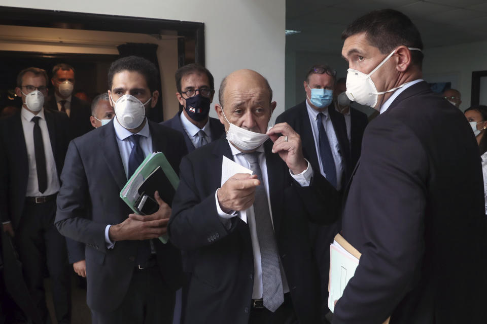 French Foreign Minister Jean-Yves Le Drian, center, wearing a mask to help prevent the spread of the coronavirus, visits the Carmel Saint Joseph school in Mechref district, south of the capital Beirut, Lebanon, Friday, July 24, 2020. Visiting Le Drian pledged on Friday €15 million ($17 million) in aid to Lebanon's schools, struggling under the weight of the country's major economic crisis. (AP Photo/Bilal Hussein)
