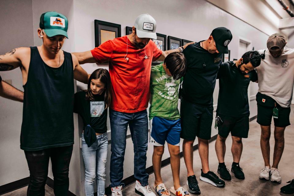 Country star Walker Hayes' kids mix in with the crew for a pre-show prayer June 10, 2023, in Boca Raton, Florida. From left, Nick Schmutte, Everly Hayes, Walker Hayes, Beckett Hayes, Matt Potesta, Shawn Gough and Brandon Dickens