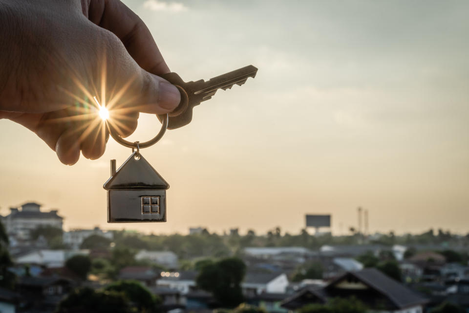 Hand holding key and house keyring