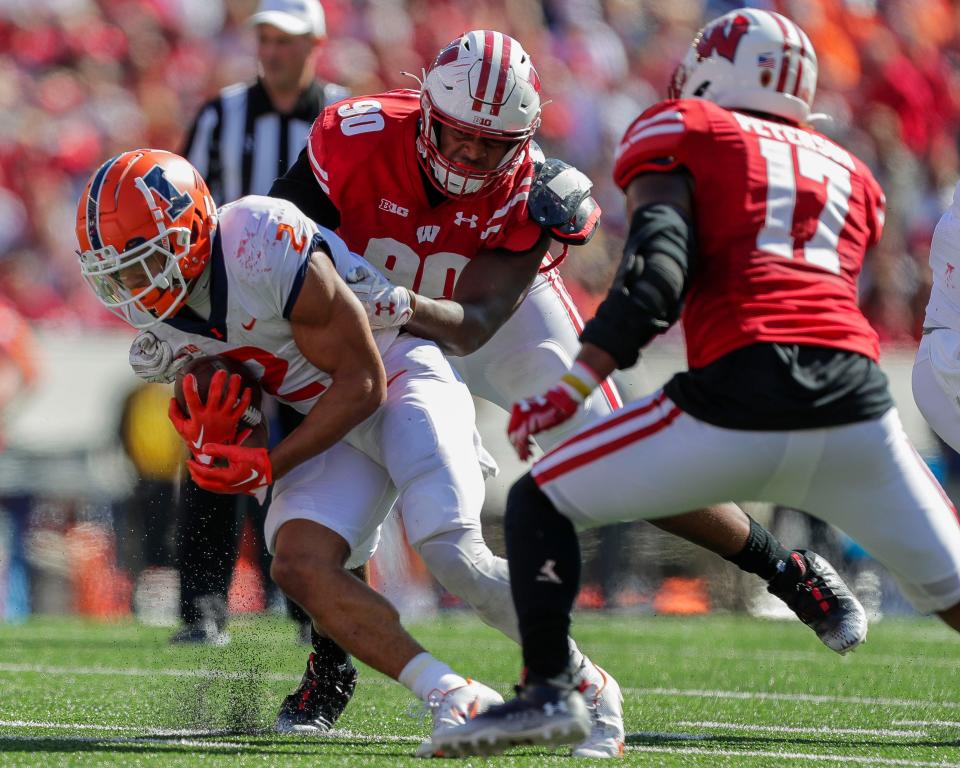 Wisconsin defensive end James Thompson Jr. (90) tackles Illinois running back Chase Brown (2) on Saturday, October 1, 2022, at Camp Randall Stadium in Madison, Wis. Illinois won the game, 34-10, in current Illini and former Badgers head coach Bret Bielema’s return to Madison.Tork Mason/USA TODAY NETWORK-Wisconsin 