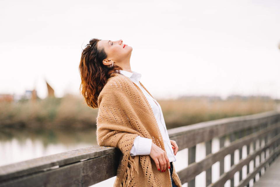 Woman outside looking up with her eyes closed