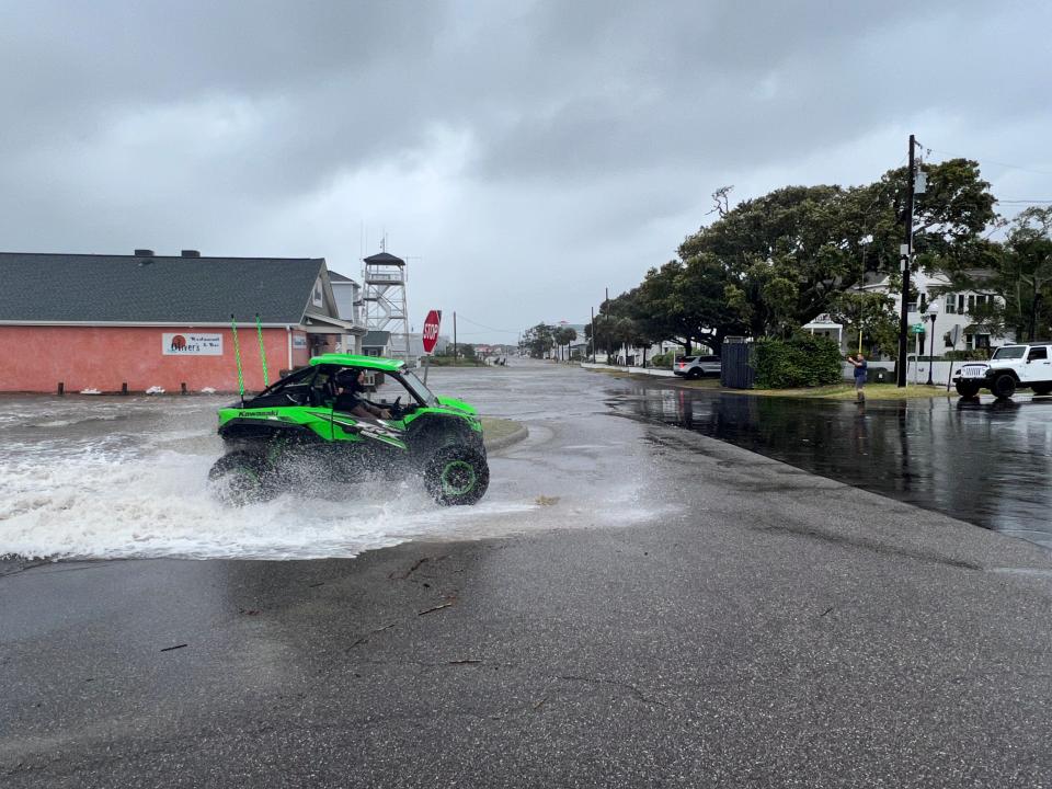 An ATV barrels through standing water in Southport.