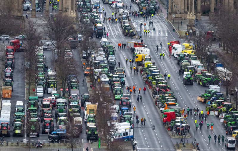 Numerous tractors, trucks and cars parked on the Strasse des 17. According to the police, around 10000 participants and 5000 vehicles are expected to take part in a large demonstration by farmers' associations and the BGL haulage association against planned subsidy cuts by the federal government, including for agricultural diesel. Monika Skolimowska/dpa