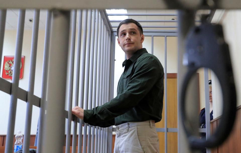 U.S. ex-Marine Trevor Reed, who was detained in 2019 and accused of assaulting police officers, stands inside a defendants' cage during a court hearing in Moscow, Russia March 11, 2020.