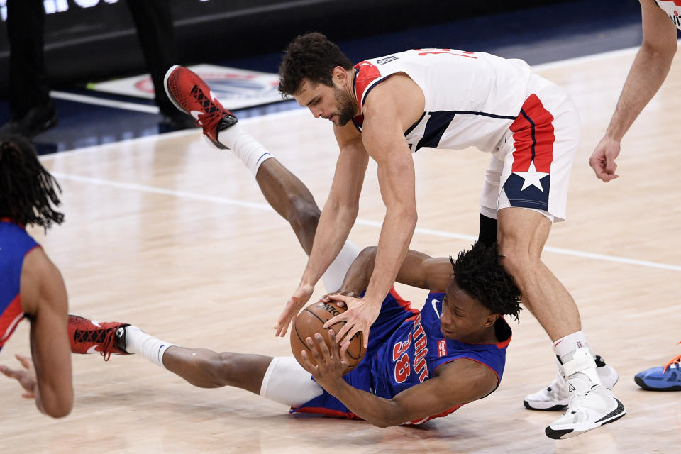 Washington Wizards guard Raul Neto, top, fights for the ball against Detroit Pistons guard Saben Lee (38) during the first half of an NBA basketball game, Saturday, April 17, 2021, in Washington. (AP Photo/Nick Wass)