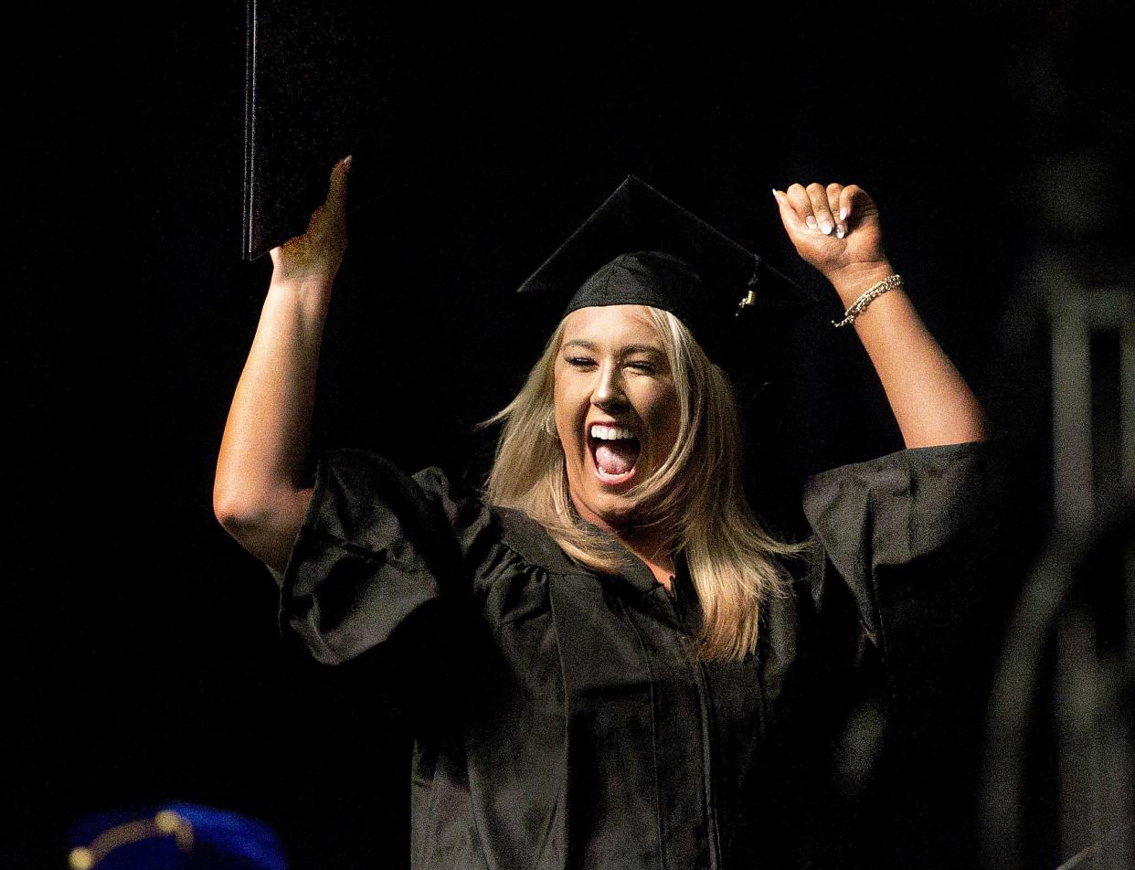 Olivia Kelso celebrates as she walks across the stage after receiving her diploma during the University of Illinois Springfield's 51st annual commencement ceremony on Saturday at the BOS Center. [Thomas J. Turney/The State Journal-Register]