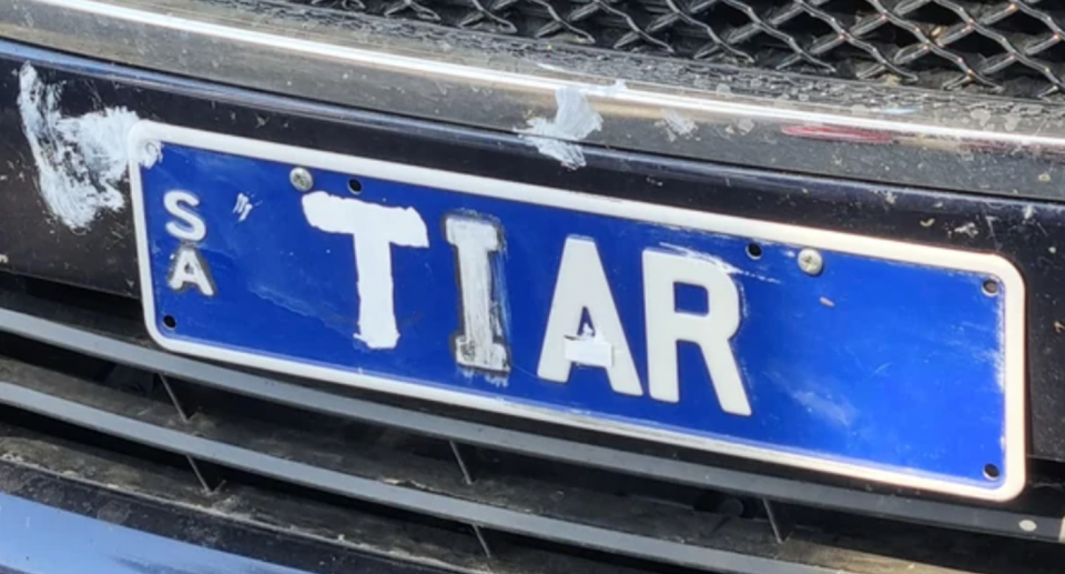 A blue and white South Australian number plate altered with white paint and tape to read TIAR.